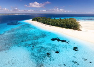 Mavi denizin ve Zanzibar 'ın muhteşem Mnemba adasının havadan görünüşü. Beyaz kumlu sahil manzarası, tekneler, yeşil palmiyeler, yazın açık gök mavisi suyu olan okyanus. Tropikal arka plan. Deniz Burnu. Seyahat