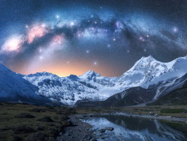 Samanyolu gece karlı dağlar ve göl üzerinde kemer. Karla kaplı kayalar, yıldızlı gökyüzü, Nepal 'deki sudaki yansıma. Yıldızlı gökyüzü. Himalayalar 'da parlak samanyolu. Boşluk. Doğa