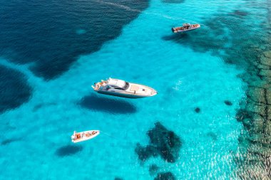 Yazın mavi denizde güzel lüks bir yat ve tekne manzarası. Sardunya, İtalya. Sürat teknesi, deniz bölmesi, şeffaf turkuaz su. Seyahat et. Tropikal renkli manzara. Yat.