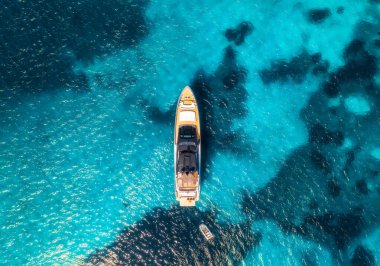 Yazın mavi denizde güzel lüks bir yatın havadan görünüşü. Sardunya, İtalya. Tekne, deniz bölmesi, şeffaf gök mavisi. Seyahat ve tatil. Tropikal renkli manzara. Yat.