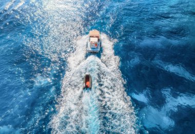 Yazın güneşli bir günde mavi denizde yüzen yatın hava manzarası. Sardunya, İtalya 'ya seyahat. Sürat teknelerinin hava manzarası, deniz lagünü, şeffaf gök mavisi suyu. Üst dron görüntüsü. Tropik deniz manzarası