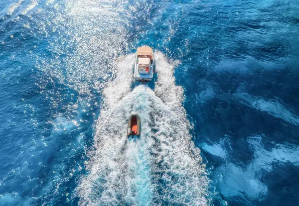 Yazın güneşli bir günde mavi denizde yüzen yatın hava manzarası. Sardunya, İtalya 'ya seyahat. Sürat teknelerinin hava manzarası, deniz lagünü, şeffaf gök mavisi suyu. Üst dron görüntüsü. Tropik deniz manzarası