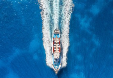 Yazın güneşli bir günde mavi denizde yüzen güzel bir yatın havadan görünüşü. Sardunya adası, İtalya. Hız teknesi, deniz kıyısı, şeffaf su. Seyahat et. Tropik bir manzara. Yat.