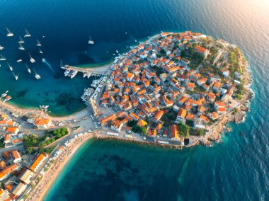 Gün batımında Aeriel 'in adadaki eski kasaba manzarası. Primosten, Hırvatistan, Adriyatik Denizi 'nde yaz mevsimi. En iyi insansız hava aracı manzaralı evler, temiz mavi sular, yat ve tekneli marina, kumlu sahil. Seyahat et. Hava manzarası