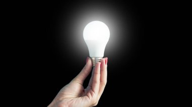 lamp in a woman's hand. female fingers holding LED lamp. idea. New idea or inspiration concept. Concept of startup. Horizontal image.
