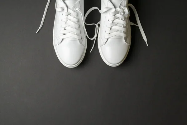 黑色底色的白色皮鞋 白色运动鞋 白色鞋带 新鞋子横向图像 — 图库照片