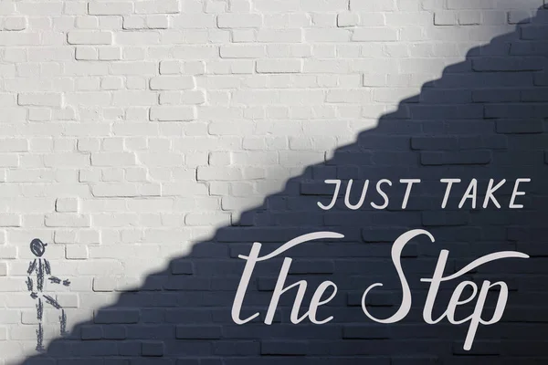 Just take the step - handwritten lettering on white brick wall, divided into light and shadow parts along the diagonal in the form of steps. A drawn man stands at the base of a staircase and looks up. White and Black. Inspiration, motivation.
