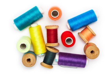 Dikiş ve nakış işlemek için renkli iplik makaraları koleksiyonu, temiz beyaz bir arkaplanda dağınık ve izole..