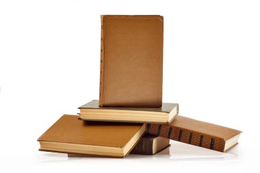 Bir kitap yığını dik duruyor ve boş kapağı beyaz arka planda izleyiciye bakıyor..