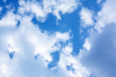 Güneş ışığıyla aydınlatılan parlak beyaz bulutlu, kusursuz bir mavi gökyüzü dokusu, arka planlar, dijital projeler ve yaratıcı tasarımlar için mükemmel..