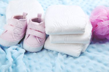 Bir çift ayakkabılı bebek bezi ve mavi arka planda bez.