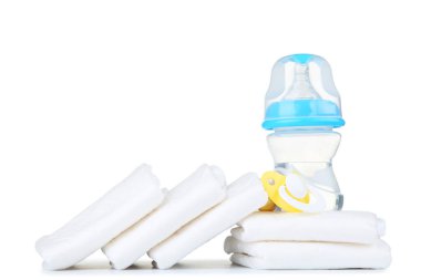 Emziği olan bebek bezleri ve beyaz arka planda izole edilmiş bir şişe su.