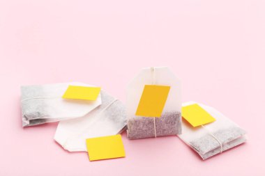 Pembe bir arka plan üzerinde çay poşetleri