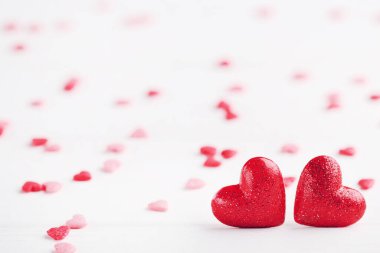 Beyaz ahşap arka planda kırmızı kalpler