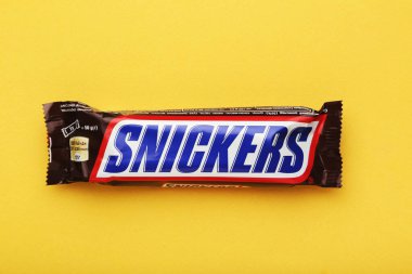 MYKOLAIV, UKRAINE - 14 HAZİRAN 2021: Sarı arka planda Snickers çikolatası