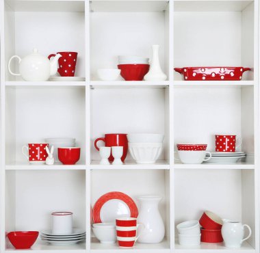 Ahşap raflarda raflar, kırmızı ve beyaz mutfak tabakları kapanıyor.