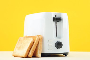 Sarı arka planda kızarmış ekmek kızartma makinesi.