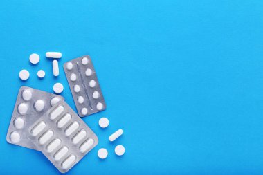 Mavi arka planda su toplayan beyaz haplar.