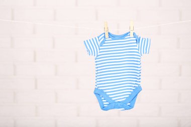 Tuğla duvar arka plan asılı bebek giysileri