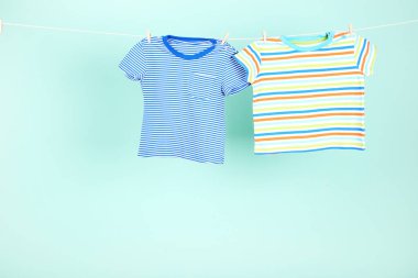 Mavi arka planda asılı bebek kıyafetleri