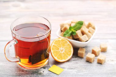 Tahta masada limon ve şeker küplü bir fincan çay.