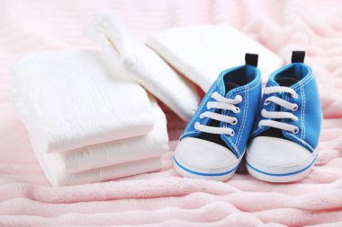 Pembe arka planda bir çift ayakkabılı bebek bezi