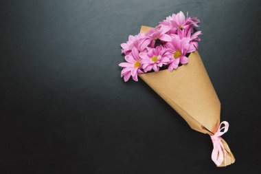 Siyah arkaplanda fotokopi alanı olan mor kasımpatı buketi. Öğretmenler Günü