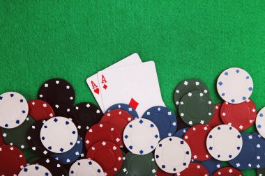 Yeşil masada poker fişleri ve kartlar