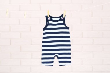 Tuğla duvar arka plan asılı bebek giysileri