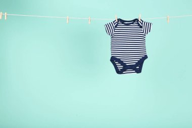 Mavi arka planda asılı bebek kıyafetleri