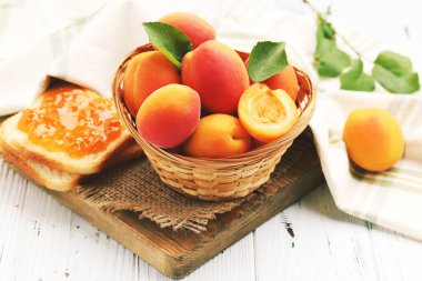 Sepette kayısılar, beyaz arka planda reçelli tost.