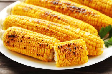 Ahşap zemin üzerinde taze ızgara mısır.