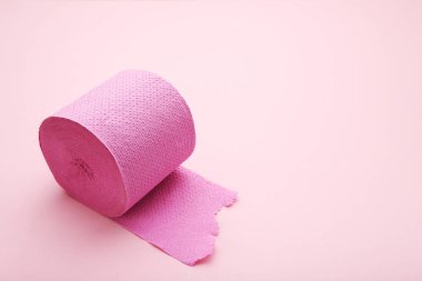 Pembe arka planda tuvalet kağıdı rulosu