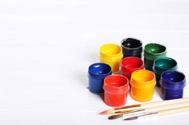 Renkli gouache beyaz ahşap masa üzerinde boya ve fırça