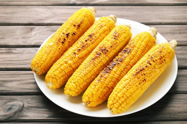 Ahşap zemin üzerinde taze ızgara mısır.