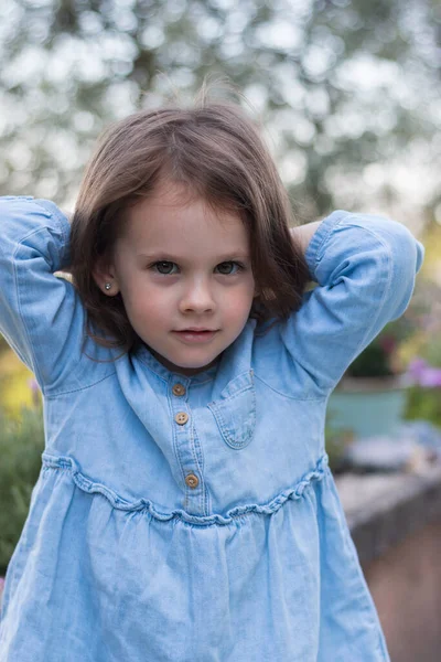 Little Beautiful Preschooler Girl Stands Denim Blue Dress Background Flowers — Stock Photo, Image