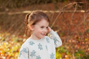 Sonbahar ormanındaki küçük bir kızın portresi. Seçici odak.