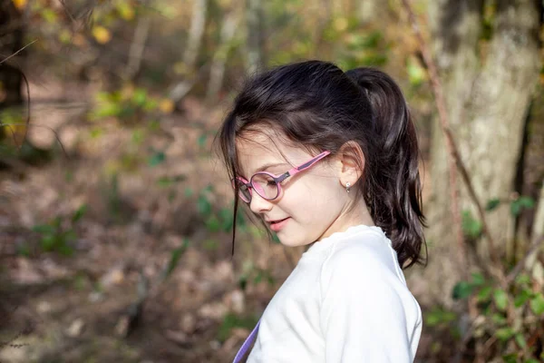 秋の森の中の眼鏡の少女の肖像画 — ストック写真