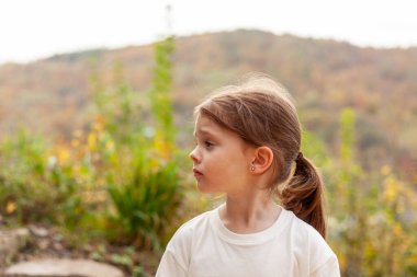 Beyaz tişörtlü küçük bir kızın portresi.