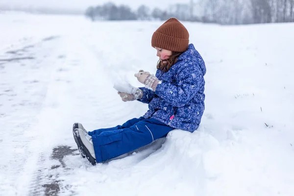 Kışlık Giysiler Içindeki Küçük Kız Karda Kayıyor Eğleniyor — Stok fotoğraf