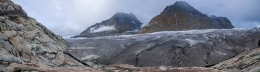 İsviçre Alplerindeki Aletch Buzulu 'nun panoramik fotoğrafı. İsviçre 'de Olmenhorn ve Gaeisshorn dağlarının arka planına karşı kocaman kirli buz blokları