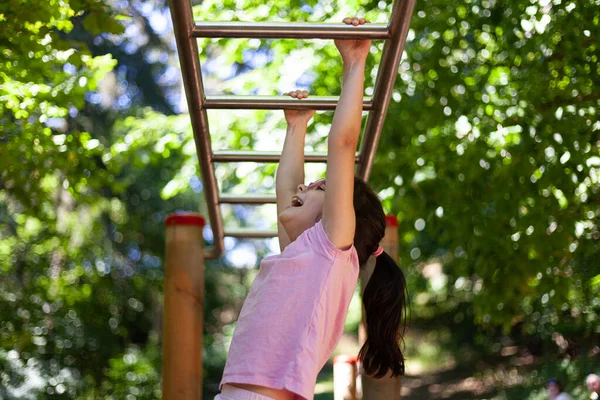 公園のサルバーでプルアップをしている若い女性 — ストック写真