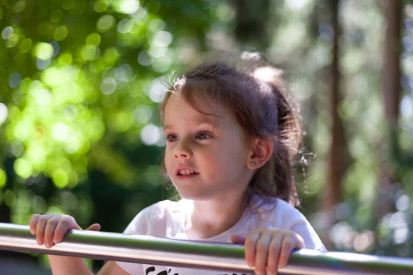 stock image Portrait of a cute little girl playing on the playground in summer