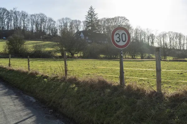 A speed limit sign on a rural road in the countryside in spring