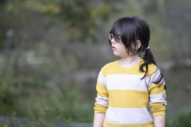 Parktaki küçük şirin bir kızın portresi, sığ bir tarla derinliği