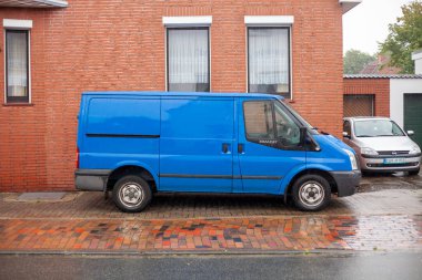 Cuxhaven, Aşağı Saksonya, Almanya. 23 Temmuz 2023 'te. Mavi eski Ford Transit teslimat minibüsü yerleşim yerindeki bir evin önüne park edilmiş.