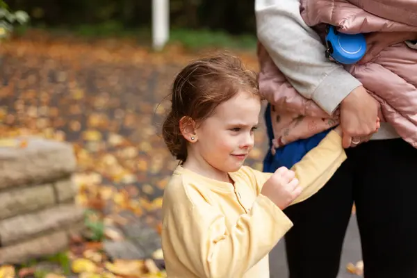 Little girl with her mother in autumn park. Selective focus.