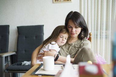 Anne ve kızı odada masada oturup çay içiyorlar.