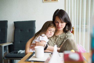 Anne ve kızı odada masada oturup çay içiyorlar.