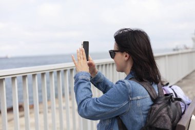 Gezinti güvertesinde selfie çeken bir kadının yan görüntüsü